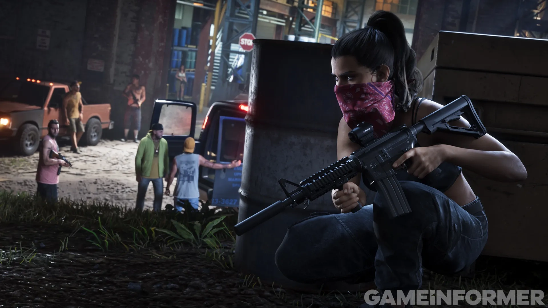 Grand Theft Auto VI protagonist Lucia taking cover behind a container holding an assault rifle with a pink bandana over her face, while gang members stand near a van in an industrial alley at night.